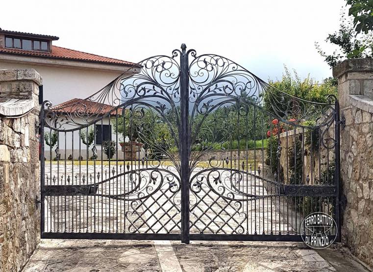 Cancello in ferro battuto con decorazioni floreali e grata